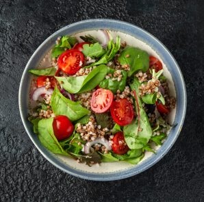 Buckwheat salad with cherry tomatoes, red onion and green vegetables. Healthy diet food.